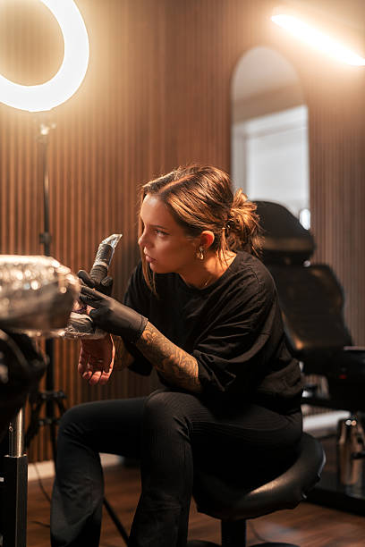istock Tattoo artist focused on creating intricate design in a professional studio 2222458825