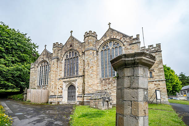 Burwash, East Sussex, UK: St Bartholomew's Church in Burwash with cemetery, trees and wall.