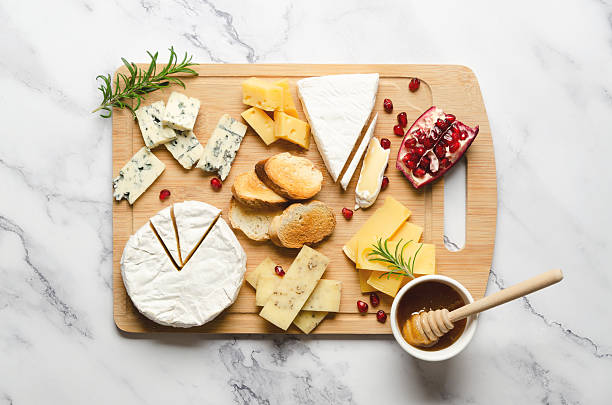 istock Assorted cheese with pomegranate and honey on a wooden board. 2222458927