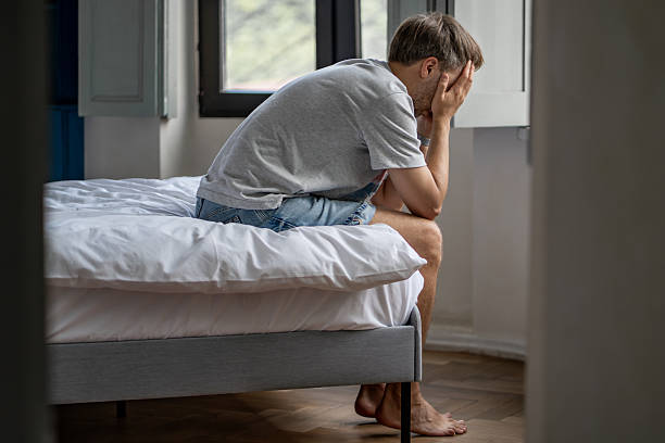 istock Distressed man sitting on bed feeling hopeless, heartbreak. Midlife crisis difficult life decisions. 2222460899
