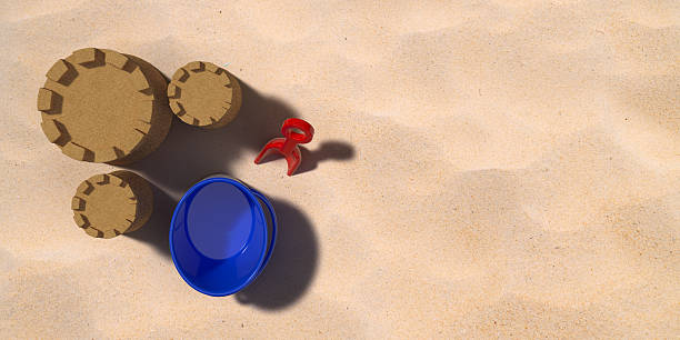 3D rendered sand castle and plastic beach toys on real sand photo backgorund. Large copy space with bright sunlight feeling.
