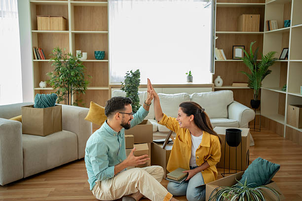 istock Happy couple giving high five while unpacking boxes in new home 2222464331
