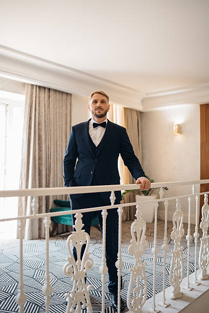 istock a Beautiful and happy groom on a large beautiful staircase. 2222466106