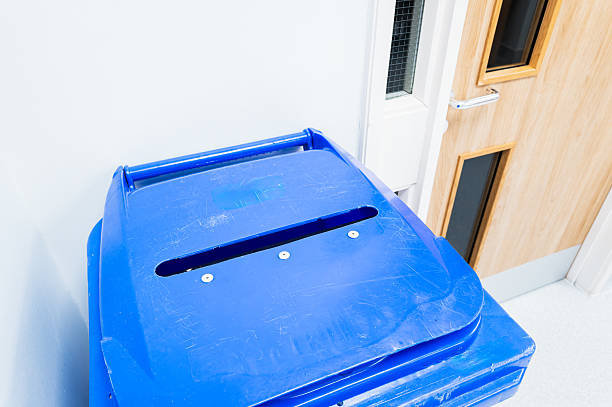 Typical secure waste bin seen in an NHS hospital in the UK. The slot allows for confidential patient documents to be discarded. The waste bin lid is locked and awaits secure shredding.