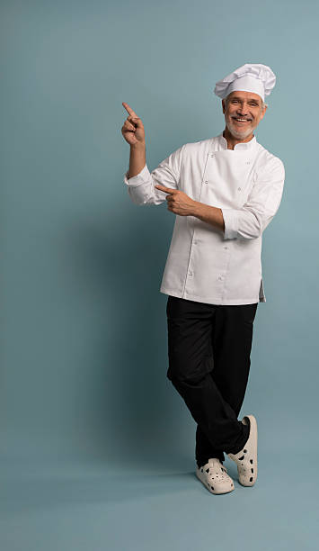 istock Mature male chef presenting something over blue background. 2222466398