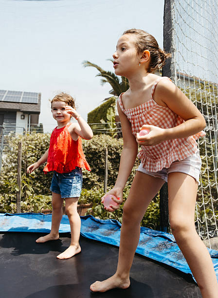istock Two girls playing with water balloons on a trampoline 2222467325