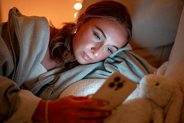 istock Young Woman Relaxing at Home While Using Her Smartphone 2222468208