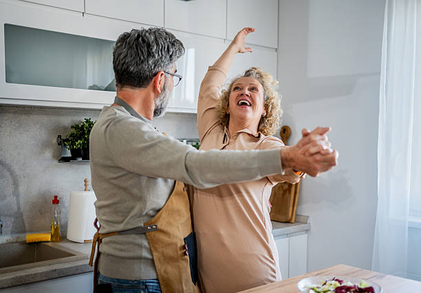istock Happy mature couple dancing and having fun while cooking together in modern kitchen 2222468317