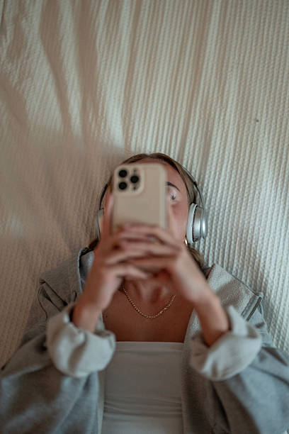 istock Woman Relaxing with Headphones and Smartphone Lying on a Comfortable Surface 2222468328