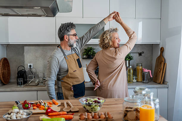 istock Happy mature couple dancing and having fun while cooking together in modern kitchen 2222468688