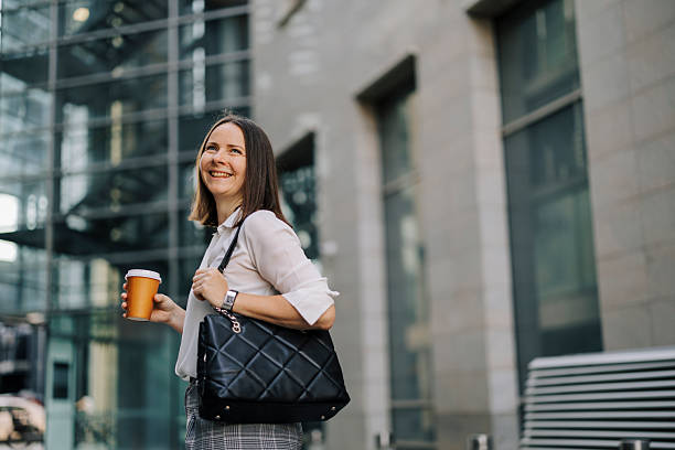 istock Beautiful businesswoman drinking coffee and walking 2222468708