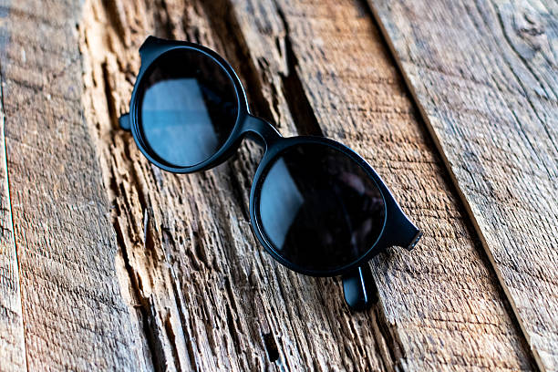 istock round sunglasses in black plastic frames on textured wood. 2222469737