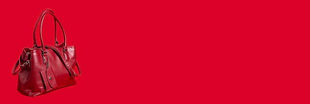 istock Red women's leather bag on a red background. Banner, space for text. 2222469891