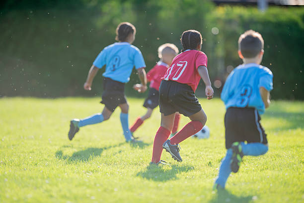 istock Children Playing Soccer Outdoors on a Sunny Grass Field 2222471042
