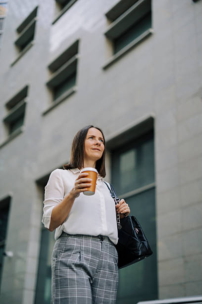istock Beautiful businesswoman drinking coffee and walking 2222471137