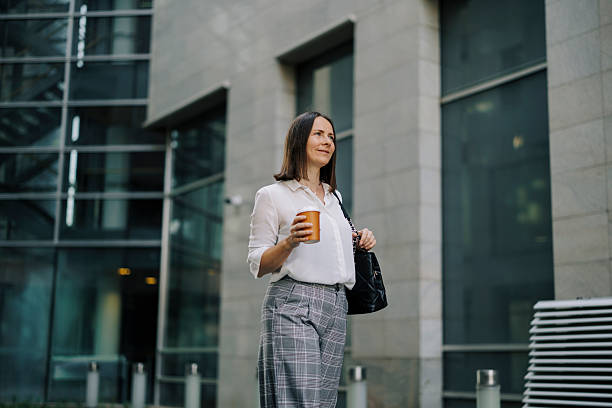 istock Beautiful businesswoman drinking coffee and walking 2222471203