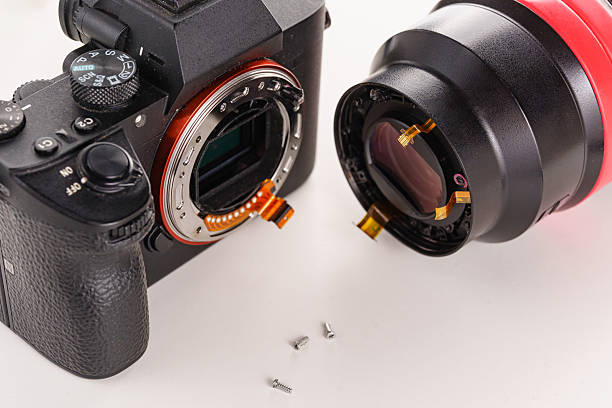 istock A broken lens, professional camera and repair tools on a white table. 2222474296