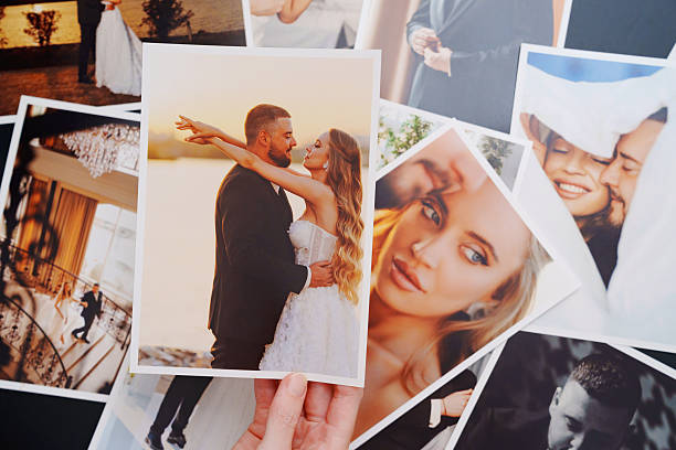 istock women's hands put on the table and show wedding photos. 2222477640