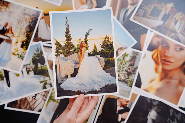 istock women's hands put on the table and show wedding photos. 2222481617