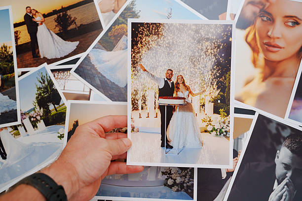 istock Men's hands put on the table and show wedding photos. 2222481764