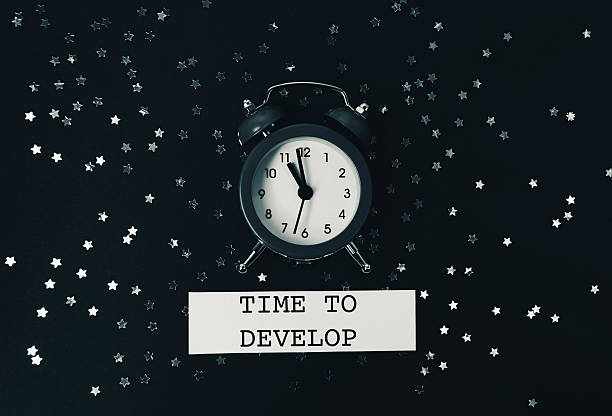 istock The clock lies on a dark background with glitter and Spitch bubbles. 2222484718