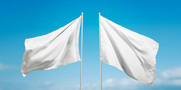 istock Two white flags waving on wind with clear sky background, representing peace, surrender or neutrality in modern visual storytelling 2222484801