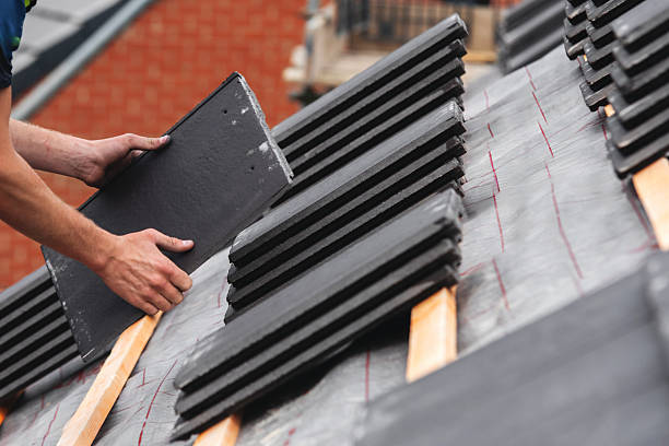 istock Roofing contractor carefully places slate roofing tiles on a structure's roof ensuring proper alignment and stability 2222485605