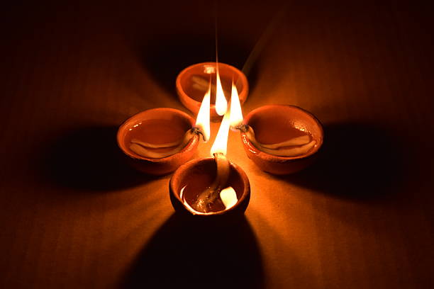 Lit earthen clay oil lamp in dark