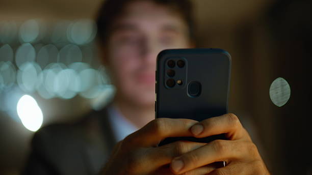 istock Late worker tapping smartphone screen browsing message at dark apartment closeup 2222491239