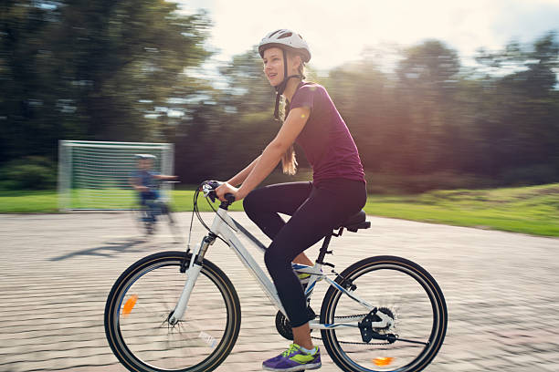 Girl is riding bicycle along the river