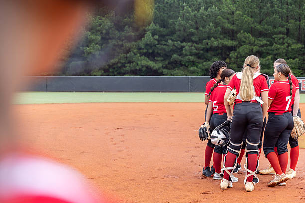 istock Softball team huddles during game at rural small town high school 2222496236