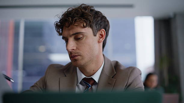 istock Thoughtful businessman sitting coworking workplace laptop. Man looking documents 2222496942