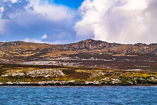 A breathtaking panoramic view of Iceland’s highlands showcasing rolling green hills, a winding path, and distant volcanic peaks beneath a dramatic sky. Shot on iPhone.