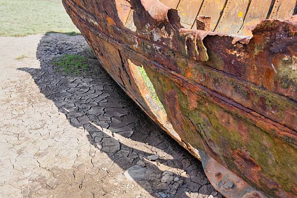 istock A rusty shipwreck lies partially buried in the sand. 2222500796