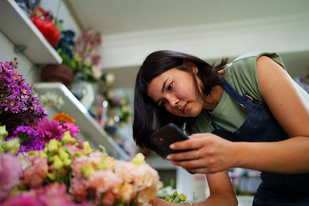 istock Florist using mobile phone at the flower shop 2222501468