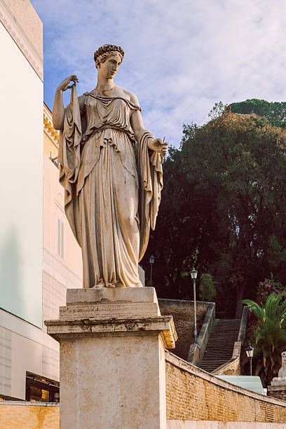 Statue of a melancholic female figure in front of a cross. Cloudy day, atmosphere of sadness.
