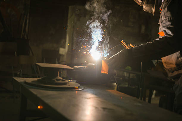 A man is welding metal with a torch. Concept of danger and risk, as the man is working with a potentially hazardous tool