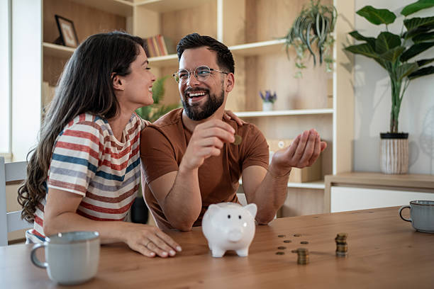 istock Young couple saving money at home using piggy bank 2222510328