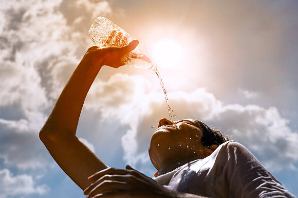 istock Young woman drinking water under the summer sun 2222510772