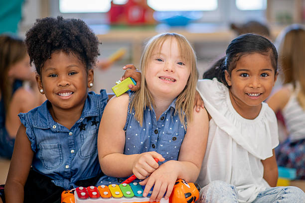 istock Three Young Children Smiling and Bonding in a Colorful Classroom Setting 2222514135