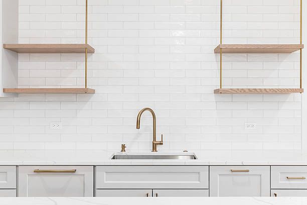 istock A gold faucet in a luxury kitchen with a white subway tile backsplash. 2222514263