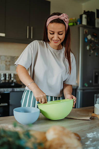 istock Young caucasian woman making bread dough in her kitchen 2222516100