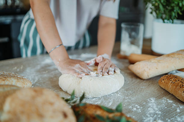 istock Young caucasian woman making bread dough in her kitchen 2222516203