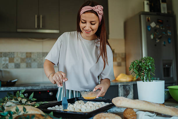 istock Young caucasian woman making bread dough in her kitchen 2222516329