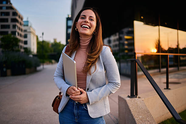 istock Happy Professional Woman Standing Outdoors Holding a Notebook at Sunset 2222519280