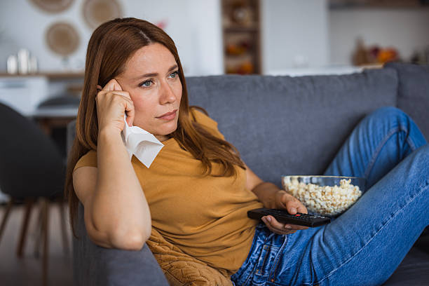 istock Bored woman watching television and holding a tissue 2222526914