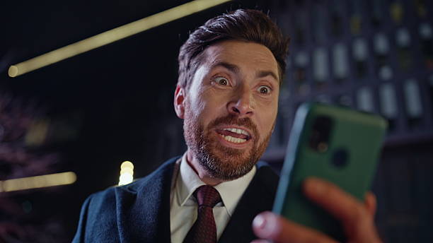 istock Evening winner reading mobile phone screen dark square portrait. Man rejoicing 2222527660