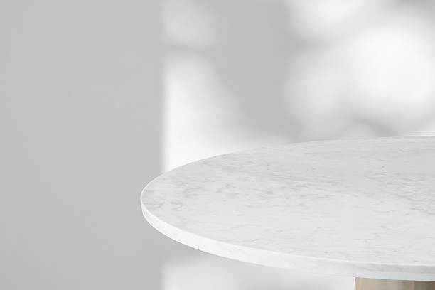 istock Round marble table top with tree leaves shadow drop on white wall background for mockup product display 2222529084