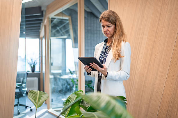 istock Professional Female Financial Advisor Using Tablet in Office Corridor 2222530255