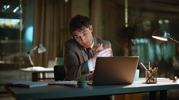 istock Entrepreneur calling late evening office laptop workplace closeup. Smiling man 2222530501